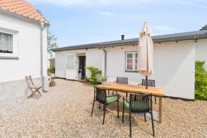 HasleにあるHolyday Home In Beatiful Vangのパティオ(木製のテーブル、椅子、パラソル付)