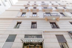 un edificio blanco alto con un cartel para un hotel en Hotel Santa Marta en Barcelona