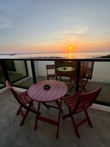 a table and chairs on a balcony with a sunset at Travel Happiness Homestay in Huxi