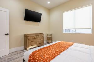 a bedroom with a bed and a flat screen tv at Spacious 4BR, Pool, Jacuzzi, Pickleball, Sauna, Cold Plunge in Desert Hot Springs