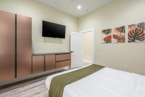 a bedroom with a bed and a flat screen tv at Spacious 4BR, Pool, Jacuzzi, Pickleball, Sauna, Cold Plunge in Desert Hot Springs