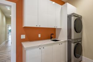 a kitchen with white cabinets and a washer and dryer at Spacious 4BR, Pool, Jacuzzi, Pickleball, Sauna, Cold Plunge in Desert Hot Springs