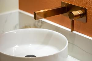 a bathroom sink with a gold faucet at Spacious 4BR, Pool, Jacuzzi, Pickleball, Sauna, Cold Plunge in Desert Hot Springs