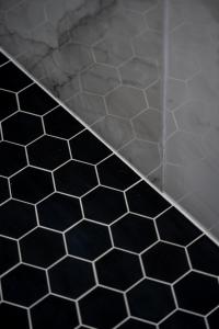 a shower with black and white tiles on the floor at Spacious 4BR, Pool, Jacuzzi, Pickleball, Sauna, Cold Plunge in Desert Hot Springs