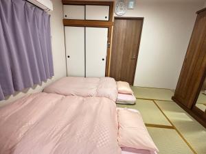 一棟貸しの宿 貸別荘 寝屋川ハウス NEYAGAWA HOUSE! for up to 10 people, 3 min walk from Keihan Kayashima Station, 京阪電車 萱島駅から徒歩3分, キーボックスの暗証番号はご予約後に宿からのメッセージ欄にてご確認下さい,にあるベッド