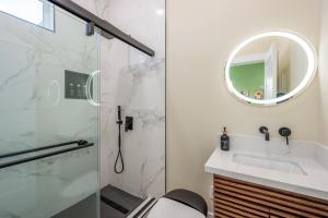 a bathroom with a shower and a sink and a mirror at Spacious 4BR, Pool, Jacuzzi, Pickleball, Sauna, Cold Plunge in Desert Hot Springs