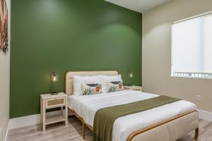 a bedroom with a large bed with green walls at Spacious 4BR, Pool, Jacuzzi, Pickleball, Sauna, Cold Plunge in Desert Hot Springs +37 photos