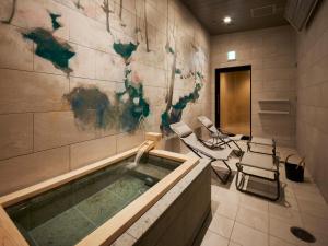 a bathroom with a jacuzzi tub with chairs in it at ES CON FIELD HOKKAIDO HOTEL Kitahiroshima Station in Kitahiroshima