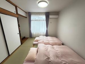 寝屋川市にある一棟貸しの宿 貸別荘 寝屋川ハウス NEYAGAWA HOUSE! for up to 10 people, 3 min walk from Keihan Kayashima Station, 京阪電車 萱島駅から徒歩3分, キーボックスの暗証番号はご予約後に宿からのメッセージ欄にてご確認下さい,の窓のあるベッドが2つある部屋