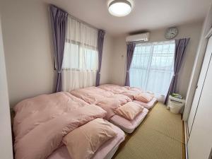 寝屋川市にある一棟貸しの宿 貸別荘 寝屋川ハウス NEYAGAWA HOUSE! for up to 10 people, 3 min walk from Keihan Kayashima Station, 京阪電車 萱島駅から徒歩3分, キーボックスの暗証番号はご予約後に宿からのメッセージ欄にてご確認下さい,の窓付きの部屋のベッド1台(ピンクのシーツ付)