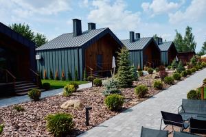 a row of wooden buildings with a garden at Сімейний Екопарк Ясногородка in Yasnogorodka