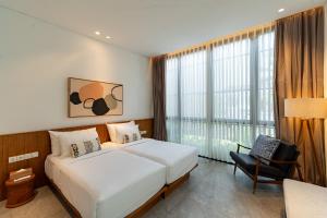 a hotel room with a bed and a chair at Botanika Estate Private Pool Villa in Canggu +72 photos