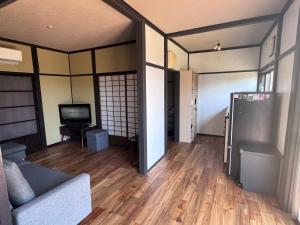 a living room with a couch and a television at Villa Thalassa 貸切 in Oshima