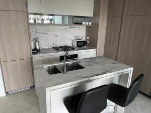 a kitchen with a sink and a microwave at Queens Wharf 50th Floor in Brisbane