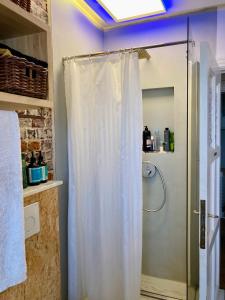 a shower with a white shower curtain in a bathroom at Calm, green & birdsong near the city center in Brussels +28 photos