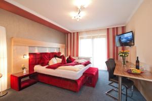 a hotel room with a large bed and a desk at Dreilandhof in Loipersdorf bei Fürstenfeld