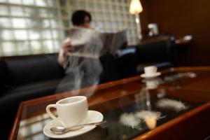 Hirosaki Plaza Hotel في هيروساكي: طاولة قهوة مع كوب قهوة وملعقة