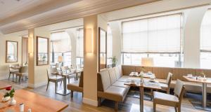 a restaurant with tables and chairs and windows at Best Western Hotel Leipzig City Centre in Leipzig