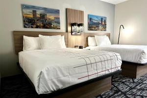 een hotelkamer met twee bedden met witte lakens bij La Quinta by Wyndham Atlanta Roswell in Roswell +59 foto's