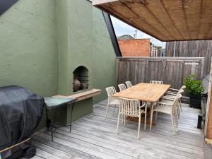 a patio with a wooden table and chairs on a deck at Sint-Catharina in Lier