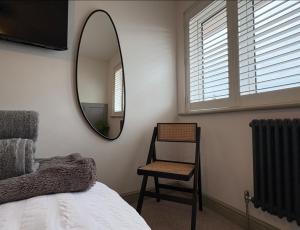 a bedroom with a mirror and a chair and a bed at Gaskell Way in Kings Lynn