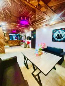 a living room with a table and a couch at Hotel Bollywood in Kasol