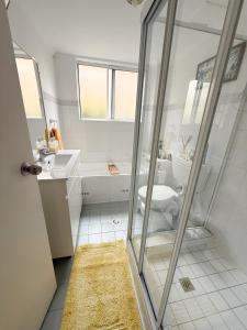 a white bathroom with a sink and a toilet at Bedroom in Sydney AU in Kirrawee