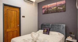 a bedroom with a bed and a picture on the wall at Big Tree Boutique in Ipoh