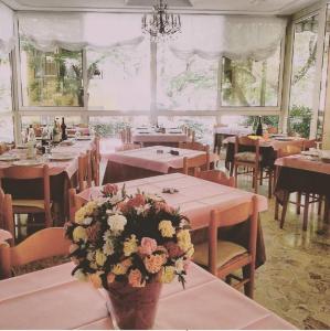una sala da pranzo con tavoli e fiori di Hotel Moby Dick a Rimini