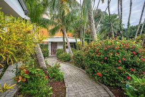 a brick walkway in front of a house with palm trees at Villa Jaco Sol in Jacó