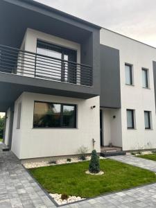 a large white house with a lawn in front of it at Mint Vibe Apartment in Odorheiu Secuiesc