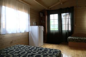 a room with a refrigerator in a room with windows at Nemirsetos Nameliai in Palanga
