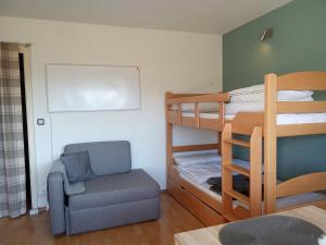 a small room with bunk beds and a chair at Komplette Wohnung Schwarzwaldpforte Casa BaLi direkte Buchung möglich keine Freigabe mehr erforderlich mit sehr ruhigem Balkon Parkplatz und eigener Waschmaschine in Bad Liebenzell