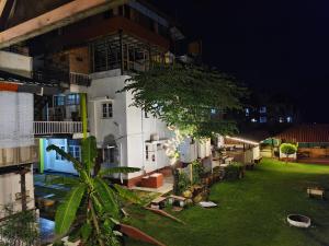a large white building with a courtyard at night at The Palmyrah Tenements in Mysore