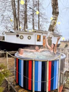a group of people in a hot tub with a boat at Cozy little house with sauna on a fishing boat in Pärnu