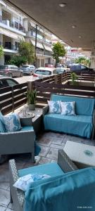 a patio with blue couches and tables and cars at Armira House in Nea Moudania
