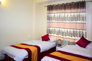 a room with two beds and a curtain at The Pahuna Apartment in Bālāju