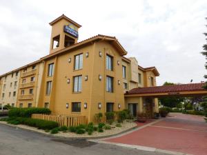 a yellow building with a clock tower on top at Days Inn & Suites by Wyndham Arlington Heights in Arlington Heights