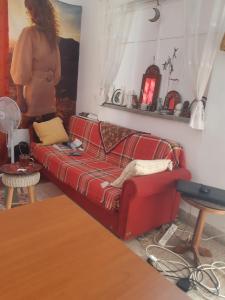 a woman standing in a living room with a red couch at Sunny Apartment in Jerusalem