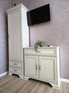 a white cabinet with a television on a wall at N&D Arinis Studio in Gura Humorului