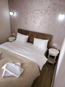 a bedroom with a large bed with white sheets and pillows at N&D Arinis Studio in Gura Humorului
