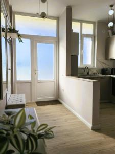 a kitchen with a white door and windows and a counter at N&D Arinis Studio in Gura Humorului