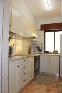 a kitchen with white cabinets and a window at Kintsugi Downtown Lagos in Lagos