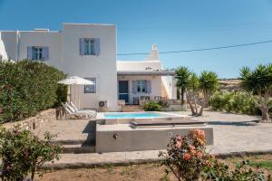 a white house with a swimming pool in front of it at Blue Xenia Villas Paros in Chrissi Akti