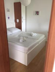 a white bed in a room with a mirror at Babe beach Apartment in Novalja