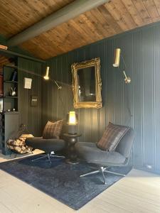 un soggiorno con un divano e uno specchio di Charming family cabin with sauna in beautiful Valdres a Gol