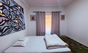 una camera da letto con un letto e un dipinto sul muro di DRAKON NEST HOMESTAY a Kathmandu