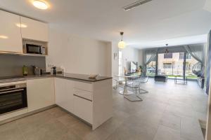 eine Küche mit weißen Schränken und ein Esszimmer in der Unterkunft Serena Village beautiful 3 bedroom terraced house close to the beach in La Cala de Mijas