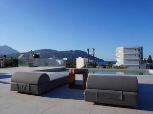 un divano e un tavolo in cima a un tetto di Avli Luxury Villas a Karpathos