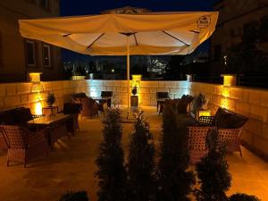a patio with an umbrella and tables and chairs at Rustic Caves in Göreme